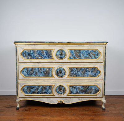 une photo d'une commode bleue et blanche posée sur un parquet