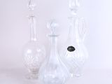 trois vases en verre posés l'un à côté de l'autre sur une surface blanche