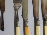 a lot of different types of knives and spoons on the table