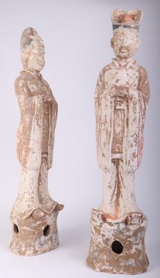 three statues of asian people are standing next to each other on a white surface