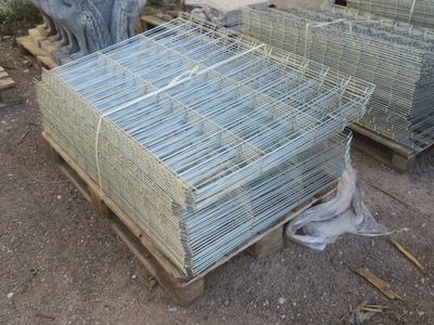 de nombreuses cages posées sur une palette, dans la boue