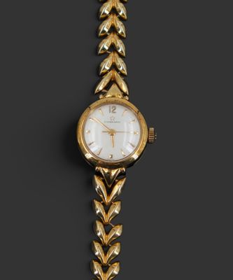 Gros plan sur une montre-bracelet en or entourée d'une chaîne
