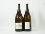 deux bouteilles de vin posées sur une table blanche