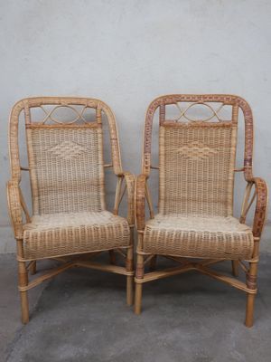 pair of wicker chairs against a wall with a white wall in the background