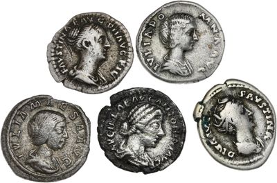 quatre pièces de monnaie romaines anciennes, dont l'une représente la tête d'une femme et une autre une tête