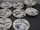 six assiettes bleues et blanches ornées d'oiseaux, posées sur une table