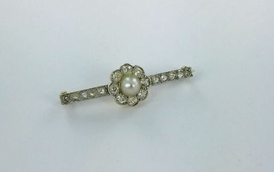 a close up of a small white pearl and diamond broocher
