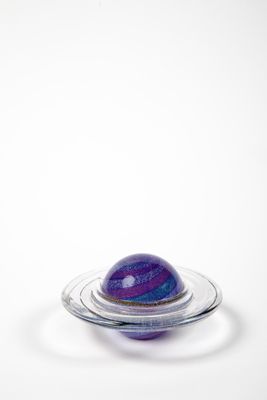une image représentant un objet en verre sur lequel se trouve une bille violette et bleue