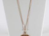 a white mannequin with a cross on it and a gold chain