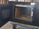 an open oven sitting on a cart in a warehouse