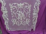 a purple blanket with a white lace design on it