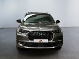 the front view of a silver car parked in a showroom