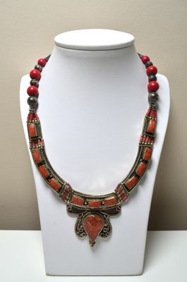 Un collier en métal argenté, serti de pierres ornementales, …