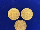 trois pièces d'or sur un fond bleu