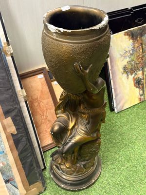 un vase en bronze posé sur un tapis vert