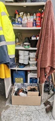 un homme debout devant une étagère remplie d'objets divers