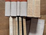Plusieurs livres sont empilés les uns sur les autres sur un plancher en bois.