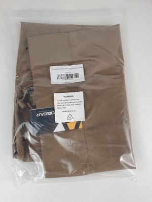 un pantalon marron dans un sac en plastique posé sur une surface blanche