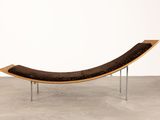 an image of a curved wooden bench with a black leather seat