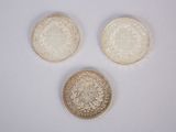 trois types de pièces différents sont présentés sur une surface blanche
