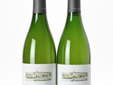 deux bouteilles de vin posées l'une à côté de l'autre sur une surface blanche