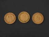 three different types of gold coins on a black surface