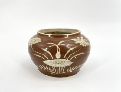 a brown vase with a white design on it