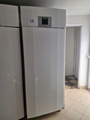 a white refrigerator in a kitchen with tile flooring