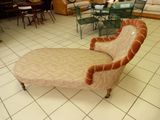 une chaise longue dans un salon avec une table et des chaises