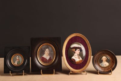 quatre portraits miniatures de femmes sont disposés en rangée sur une table