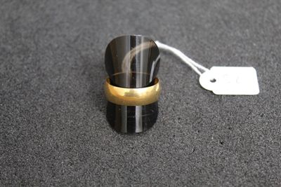 une bague posée sur une table à côté d'une étiquette