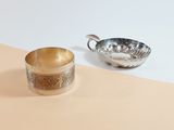 silver plated cup and saucer on a beige and white background