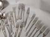 many forks and spoons laid out on the table