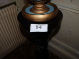 un vase bleu avec un socle doré posé sur une table