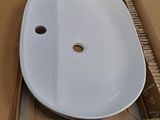 a white sink sitting in a cardboard box on the floor