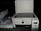 a white printer sitting next to a box on a table