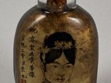 a small glass bottle with a picture of a woman on it