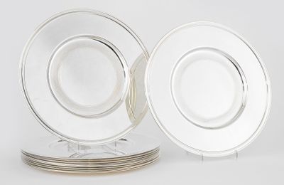 two clear glass plates with silver rims on a white surface