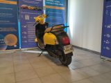 yellow and black scooter parked in front of a blue and white banner