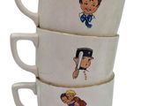 three white coffee cups with pictures of children on them stacked on top of each other
