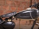 a black motorcycle parked in front of a brick wall