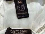 two white shirts with black and white labels on them hanging on a rack