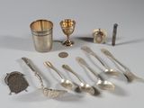 beaucoup de cuillères en argent et d'autres objets en argent sur une table