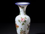 a white vase with a floral design on it