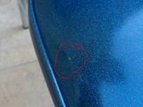 a small red circle on the seat of a blue chair
