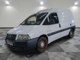 une camionnette blanche garée sur un sol en damier