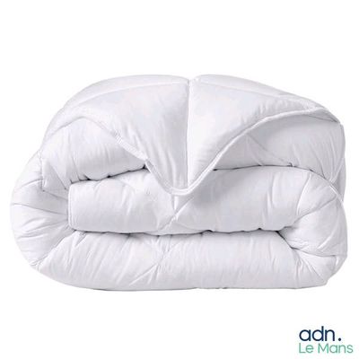 La couette est blanche et comporte une fermeture à glissière.