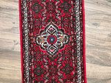 a red runner rug on a wooden floor next to a wooden floor