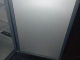 a small refrigerator that is open in the kitchen
