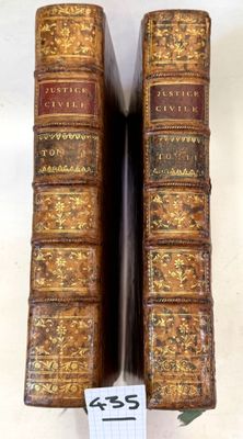 two old books sitting on top of a table next to each other